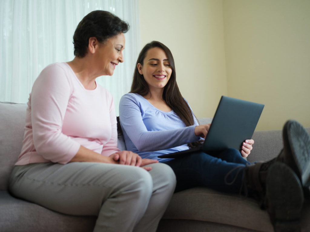 Younger & older woman using laptop together