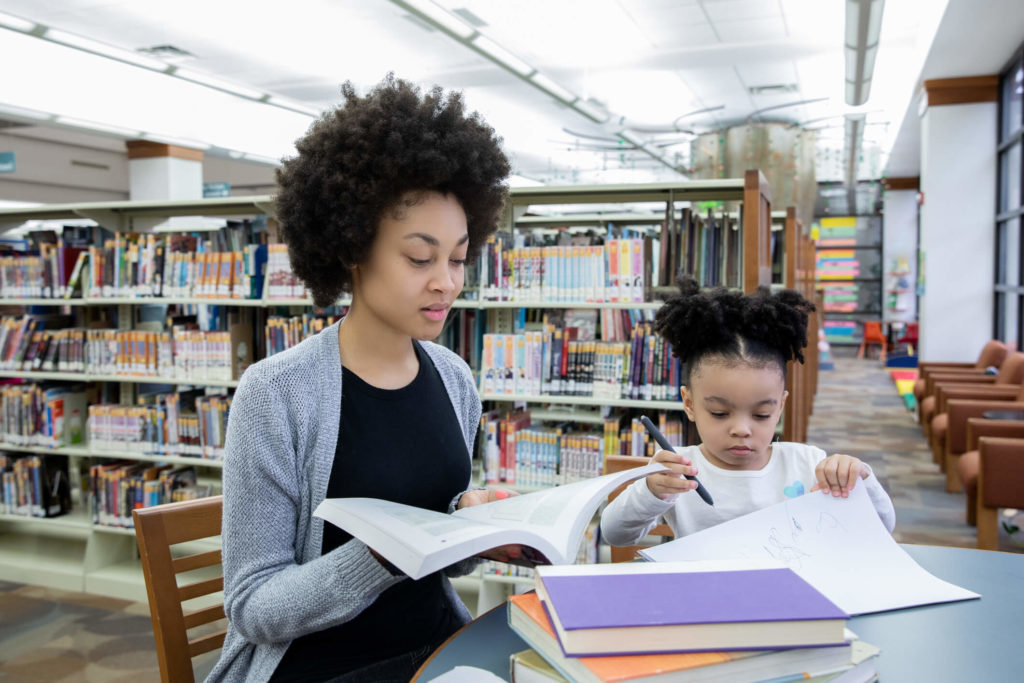 Mom & daughter use a library