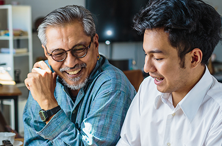 Younger man & older man smiling and talking